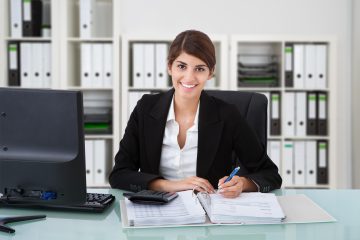 Female Accountant Writing On Documents