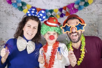 Happy disguised family celebrating carnival at home.